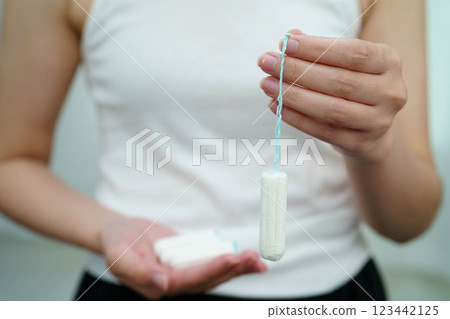 Asian woman holding cotton tampons for hygiene menstrual period cycle protection. Asian woman holding cotton tampons for hygiene menstrual period cycle protection. 123442125