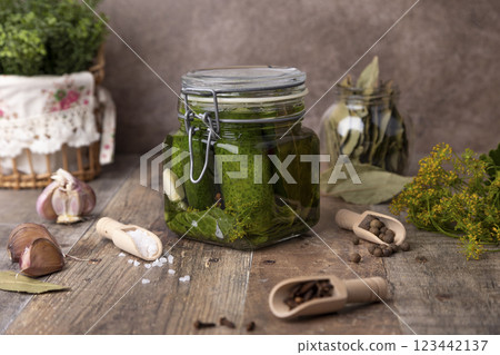 Half-sour dill pickle (quick pickled cucumbers) in a jar with seasonings, spices and herbs. Homemade seasonal preparations. Traditional canning of vegetables. Selective focus, close-up. Half-sour dill pickle (quick pickled cucumbers) in a jar with seasonings, spices and herbs. Homemade seasonal preparations. Traditional canning of vegetables. Selective focus, close-up. 123442137