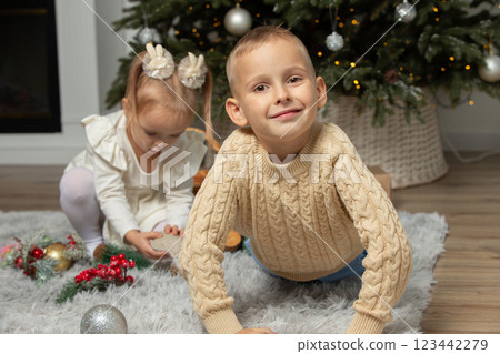 Small children play in the room on Christmas Eve. Small children play in the room on Christmas Eve. 123442279