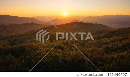 Mountain landscapes reveal scenic sunrises and sunsets painting the sky with clouds over forested hills and valleys 123444797