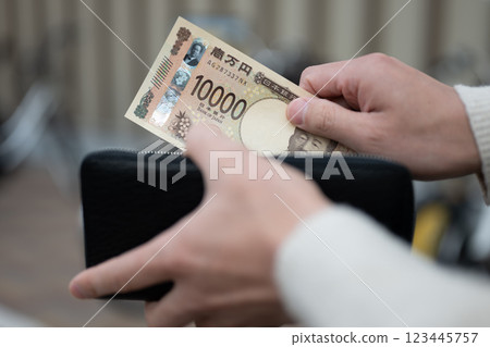 A man who puts money out of his wallet 123445757