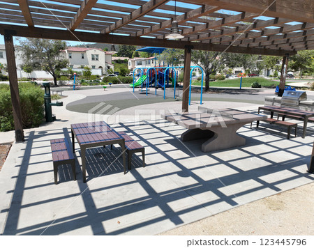 Covered gathering area in city park with green wood picnic tables Covered gathering area in city park with green wood picnic tables 123445796