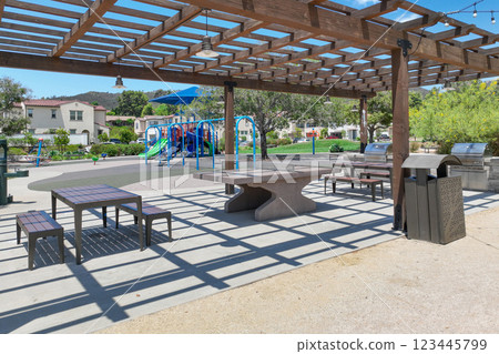 Covered gathering area in city park with green wood picnic tables Covered gathering area in city park with green wood picnic tables 123445799