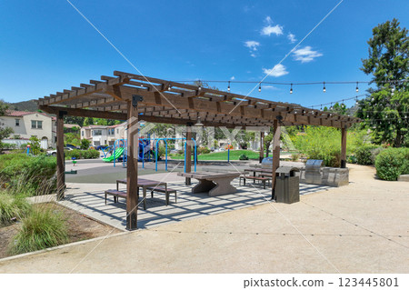 Covered gathering area in city park with green wood picnic tables Covered gathering area in city park with green wood picnic tables 123445801