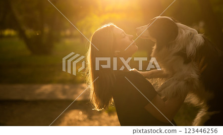 Young Caucasian woman hugging her border collie dog while walking in the park. Young Caucasian woman hugging her border collie dog while walking in the park. 123446256