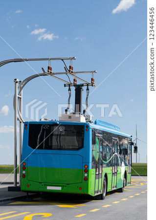 Electric bus at a stop is charged by pantograph. 123446456