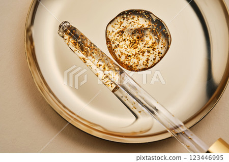 24 k gold facial serum in a pipette on a gold background. 24 k gold facial serum in a pipette on a gold background. 123446995