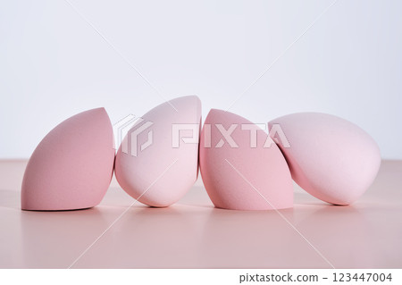 A set of makeup sponges on a pink background. 123447004