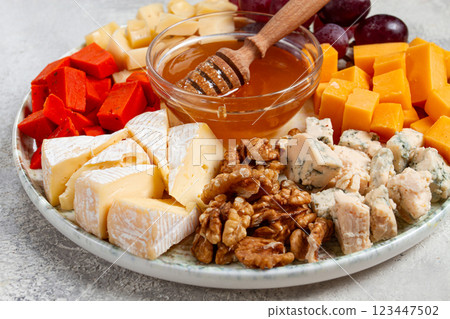 Appetizer, assorted cheese, with nuts and honey, on a round plate, top view, no people, Appetizer, assorted cheese, with nuts and honey, on a round plate, top view, no people, 123447502
