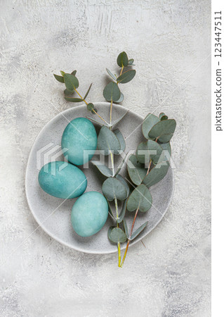 Easter colored eggs, in turquoise tones, on a gray plate, with a branch of eucalyptus, Easter card, top view, no people Easter colored eggs, in turquoise tones, on a gray plate, with a branch of eucalyptus, Easter card, top view, no people 123447511