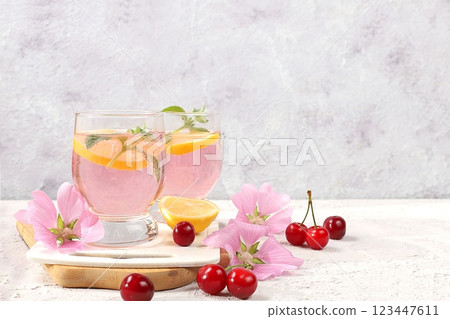 Cherry iced tea or mint and lemon cocktail, a refreshing summer drink recipe. Glass with apple fruit lemonade on light concrete table, detox diet and weight loss concept, restaurant menu Cherry iced tea or mint and lemon cocktail, a refreshing summer drink recipe. Glass with apple fruit lemonade on light concrete table, detox diet and weight loss concept, restaurant menu 123447611