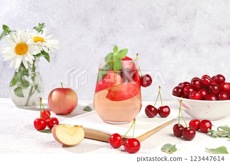 Autumn vitamin mulled wine with apple slices and mint.Apple cider, juice or fruit drink in a glass on a sunny table, Diet and weight loss concept. Apples help cleanse the body and reduce 123447614