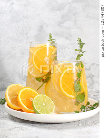 Detox drink with lemon, mint, lime and orange on a light table, a cocktail improves metabolism and promotes weight loss, healthy lifestyle concept, selective focus Detox drink with lemon, mint, lime and orange on a light table, a cocktail improves metabolism and promotes weight loss, healthy lifestyle concept, selective focus 123447807