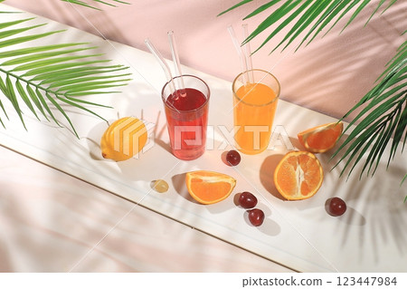 Modern still life with citrus, orange and grape juice, oranges and grapes on a pastel background with long hard shadows, minimal detox diet concept, summer vitamin drinks, selective focus, space for Modern still life with citrus, orange and grape juice, oranges and grapes on a pastel background with long hard shadows, minimal detox diet concept, summer vitamin drinks, selective focus, space for 123447984