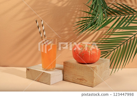 Pumpkin drink, juice on a light background .Modern still life on a pastel background with long hard shadows, minimal detox concept, traditional thanksgiving drink rich in antioxidants, used for weight 123447998