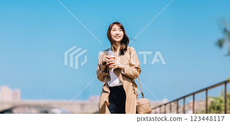 Smiling woman/businesswoman walking through the city in spring Smiling woman/businesswoman walking through the city in spring 123448117