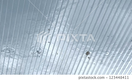 Heavy rain drumming on the transparent plexiglass roof. Beautiful rainy scene on summer day. Concept of tranquility nature scene. Close up Slow motion Heavy rain drumming on the transparent plexiglass roof. Beautiful rainy scene on summer day. Concept of tranquility nature scene. Close up Slow motion 123448411