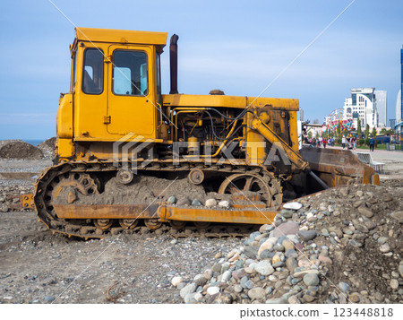 Bulldozer for excavation. Tractor from the Chelyabinsk Tractor Plant. Part of an orange tractor. Soil of pebbles and earth Bulldozer for excavation. Tractor from the Chelyabinsk Tractor Plant. Part of an orange tractor. Soil of pebbles and earth 123448818