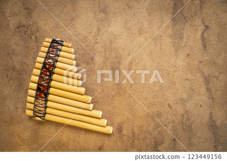 bamboo pan flute instrument from Peru against textured art paper with a copy space bamboo pan flute instrument from Peru against textured art paper with a copy space 123449156