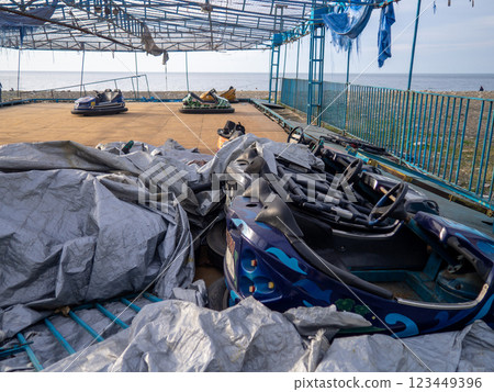 Abandoned Luna Park. Autodrom. Cars are covered with tarpaulins. Old carousels. Does not work. Broken attraction. resort in winter. Broken business. Emptiness. 123449396