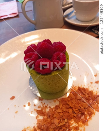 Matcha mousse dessert topped with raspberries 123449509