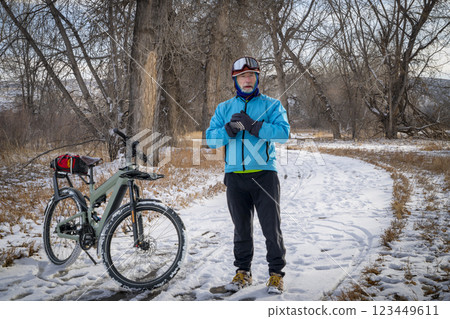 senior male cyclist with a touring electric bike on Poudre River Trail in northern Colorado, winter scenery 123449611