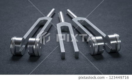 Set of weighted and unweighted metal tuning forks used for tuning musical instruments, sound therapy, chakra healing or relaxation. 123449716