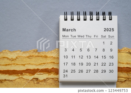February 2025 - small spiral desktop calendar with a pen, time and business concept 123449753