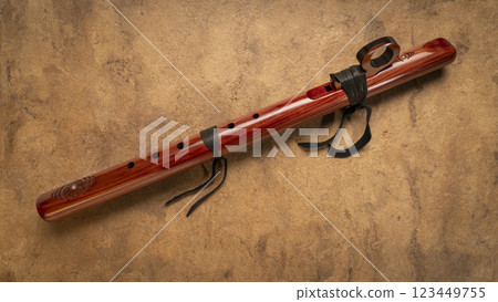 native American style flute handcrafted from aromatic cedar wood against art paper 123449755