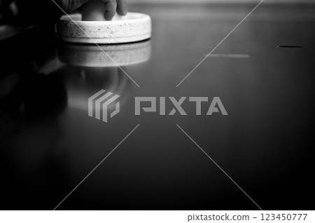 Selective focus on an air hockey table and a small child holding the paddle.  123450777