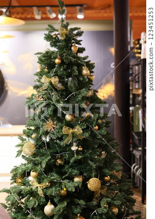 A beautifully designed Christmas tree adorned with elegant gold ornaments and greenery 123451253