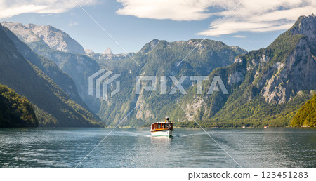 Boat on lake, framed by majestic mountains and sky. 123451283