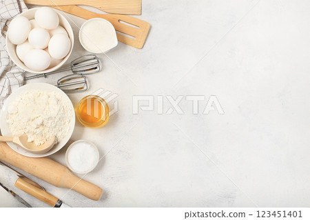 Kitchen background for baking and cooking cake, bread, confectionery and ingredients for cooking, milk, honey, flour, salt, sugar, eggs and cream on a concrete background with space for text, 123451401