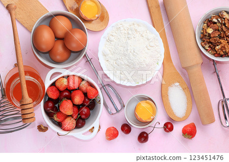 The recipe for making strawberry cherry pie, cooking. Eggs, flour, Sazar, strawberries and honey, top view, flat lay. Background of bakery products, the concept of a modern bakery 123451476