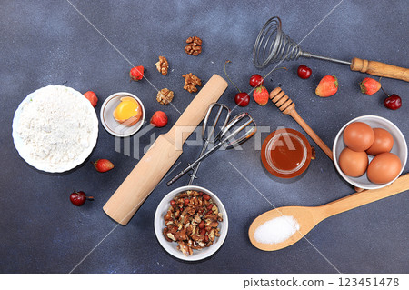The recipe for making strawberry cherry pie, cooking. Eggs, flour, Sazar, strawberries and honey, top view, flat lay. Background of bakery products, the concept of a modern bakery 123451478