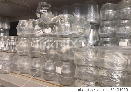 Glass jars stacked in neat rows on a display shelf at a local store 123451693