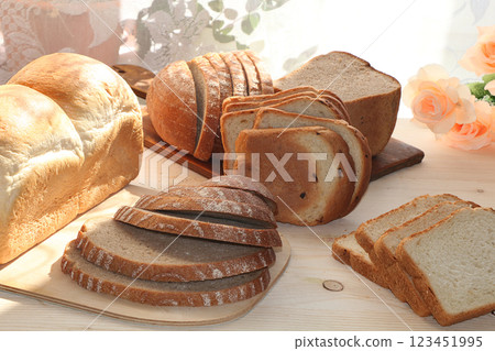 A loaf and slices of fresh bread on a sunny table. Healthy food and healthy ecological product. 123451995