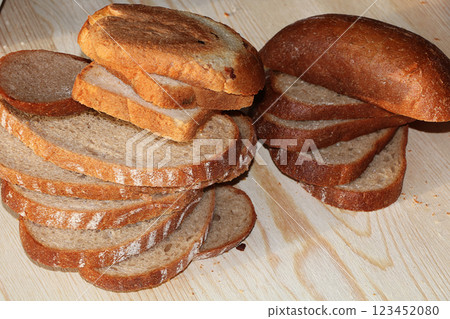A loaf and slices of fresh bread on a sunny table. Healthy food and healthy ecological product. 123452080