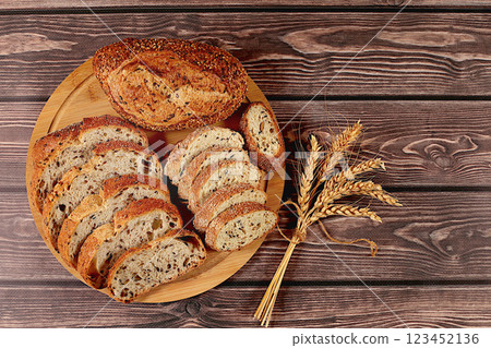 Sliced freshly baked whole grain homemade sourdough bread with crispy crust and sprouting wheat on wooden table, modern baking concept, healthy natural food Sliced freshly baked whole grain homemade sourdough bread with crispy crust and sprouting wheat on wooden table, modern baking concept, healthy natural food 123452136