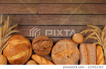 Freshly baked whole grain homemade bread, assorted varieties of round sourdough bread with crispy crust and ears of rye and wheat on a wooden background with space for text, modern baking concept, Freshly baked whole grain homemade bread, assorted varieties of round sourdough bread with crispy crust and ears of rye and wheat on a wooden background with space for text, modern baking concept, 123452163