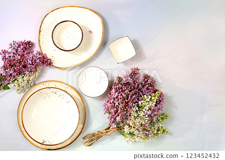Elegant festive table setting, menu design in a cafe or restaurant, cutlery with lilac flowers on a plate on a marble background, festive composition with a bouquet, kitchen background. Elegant festive table setting, menu design in a cafe or restaurant, cutlery with lilac flowers on a plate on a marble background, festive composition with a bouquet, kitchen background. 123452432