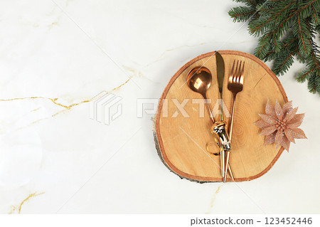 Christmas table setting. Festive New Year's cutlery with napkin on a wooden stand, festive composition, kitchen background. Selective focus 123452446