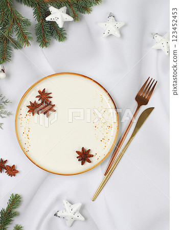 Christmas table setting, holiday menu layout, New Year's cutlery with napkin on a plate on a marble concrete background, festive composition with fir branches, kitchen background. Selective focus 123452453