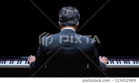 Musician plays piano in a dark setting during an emotional performance 123452869
