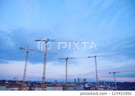 Construction cranes on the background of the sky at sunset. Construction of new residential complex. 123452992