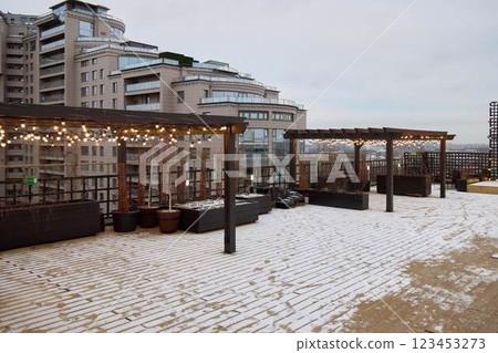 A Winter Rooftop Lounge featuring a Scenic Urban View, ideal for relaxation and enjoyment A Winter Rooftop Lounge featuring a Scenic Urban View, ideal for relaxation and enjoyment 123453273
