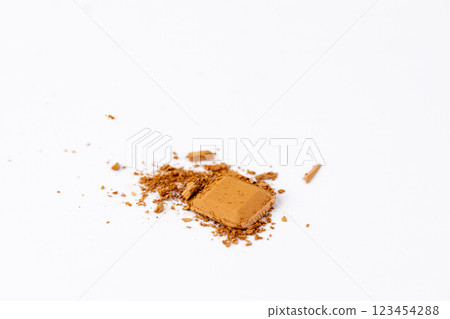 A Close-Up of a Piece of Crushed Brown Powder on a Clean White Background, Perfect for Creative Projects and Artistic Endeavors A Close-Up of a Piece of Crushed Brown Powder on a Clean White Background, Perfect for Creative Projects and Artistic Endeavors 123454288