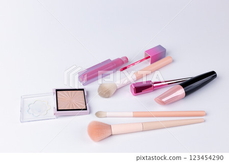 A Beautiful Display of Makeup Products Featuring Brushes and Lip Gloss in Pink and Beige Shades for a Stunning Beauty Collection 123454290
