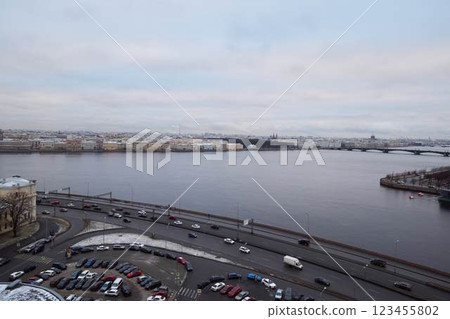 A stunning view of a serene river set against an urban landscape during the winter season 123455802