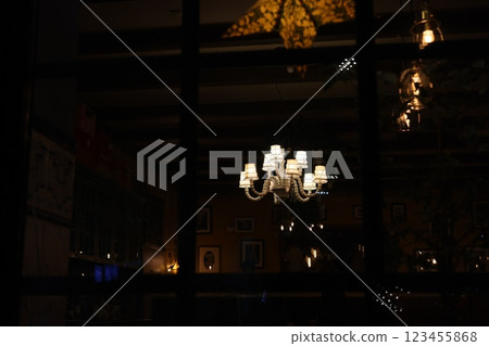 An Elegant Chandelier Reflection in the Dimly Lit and Cozy Restaurant Interior Atmosphere An Elegant Chandelier Reflection in the Dimly Lit and Cozy Restaurant Interior Atmosphere 123455868